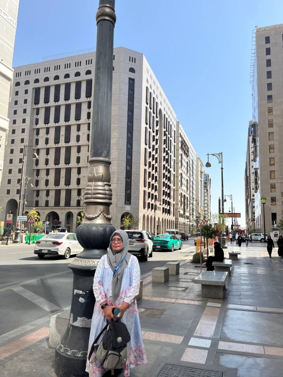 Jamaah berjalan di jalan utama Madinah di dekat menara jam