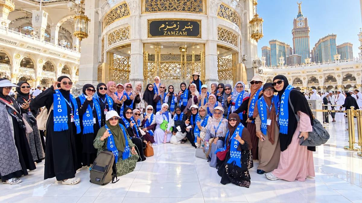 Jamaah berfoto bersama di serambi Masjid Nabawi dengan kubah hijau dan menara di belakang